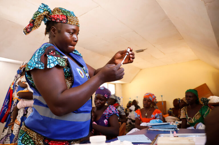 A nurse prepares to administer a malaria vaccine to infant at the health center in Datcheka